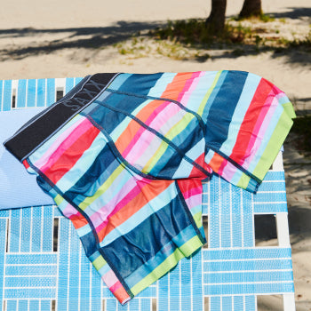 Striped boxer briefs on beach chair by palm trees