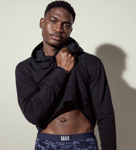 Man wearing a black hoodie and navy blue Boxer Briefs in camouflage print