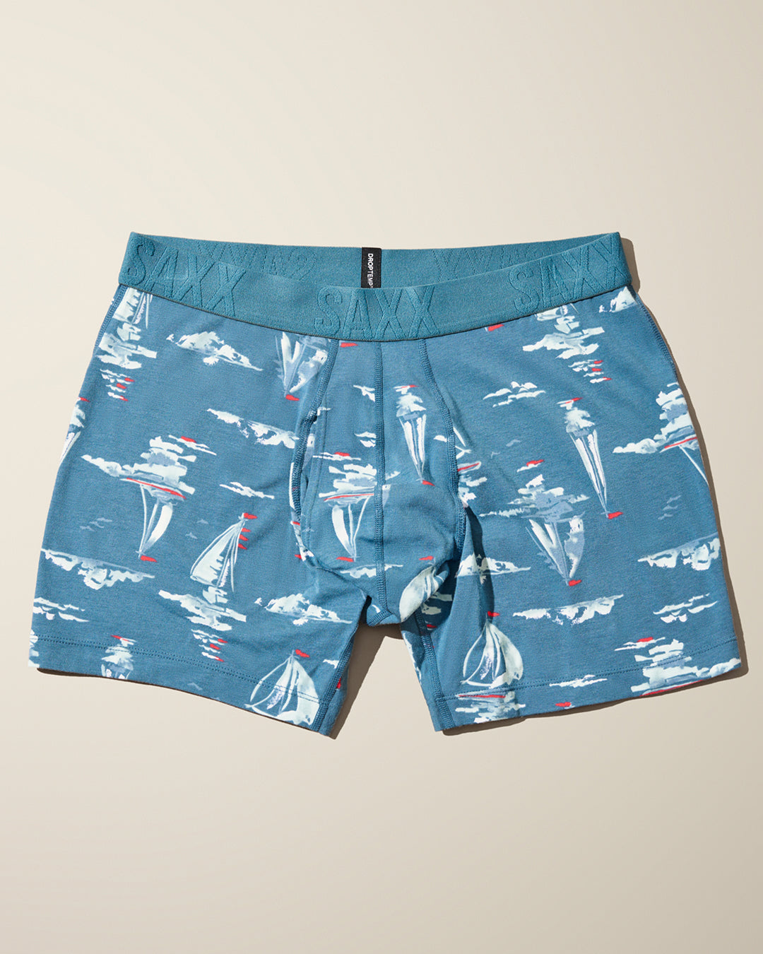 Blue boxer briefs with sailboat pattern on a beige background