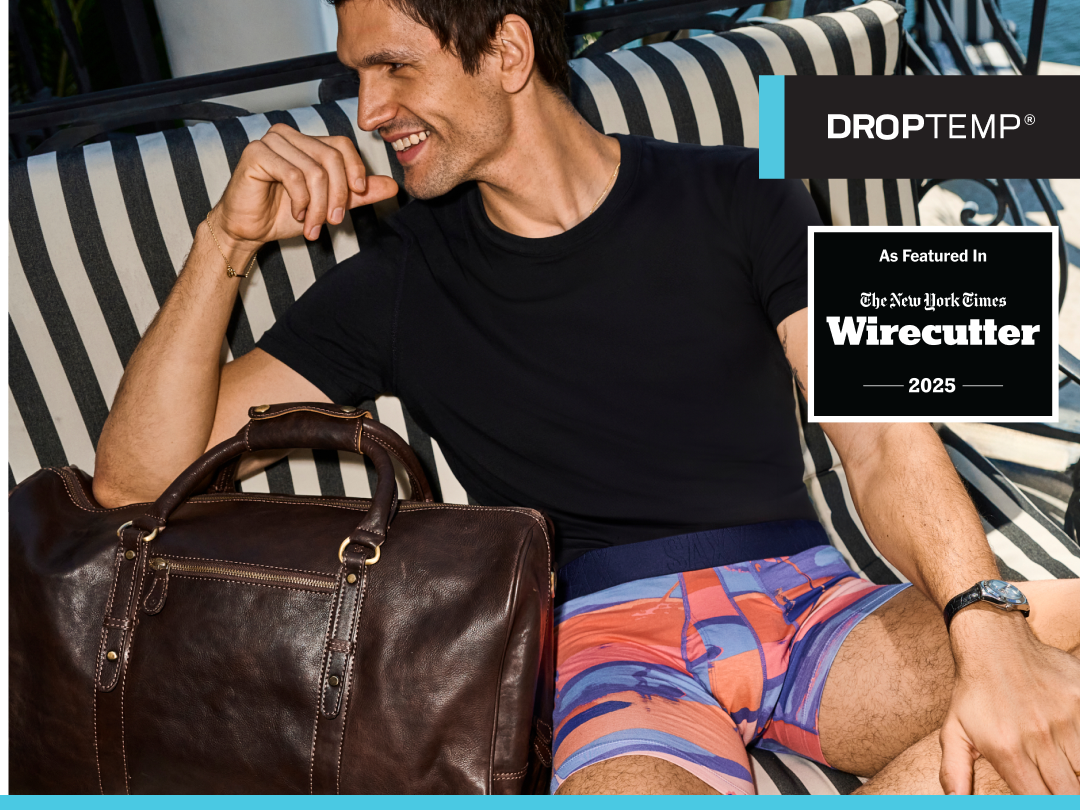 Man in underwear and black shirt sitting on striped couch with leather bag