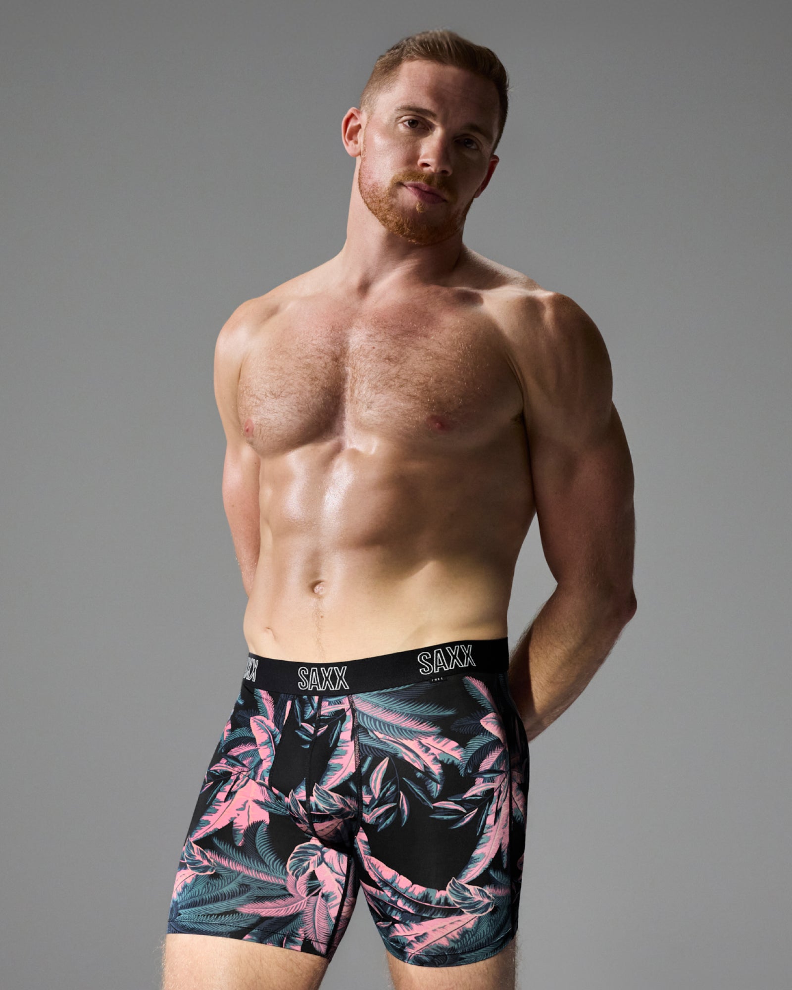 Model poses in SAXX Free DropTemp All Day Cooling Boxer Brief in Tropical Jungle-Black