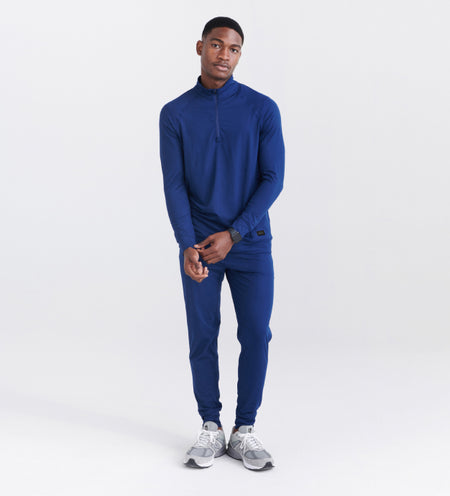 Man wearing blue half zip long sleeve top and sweatpants