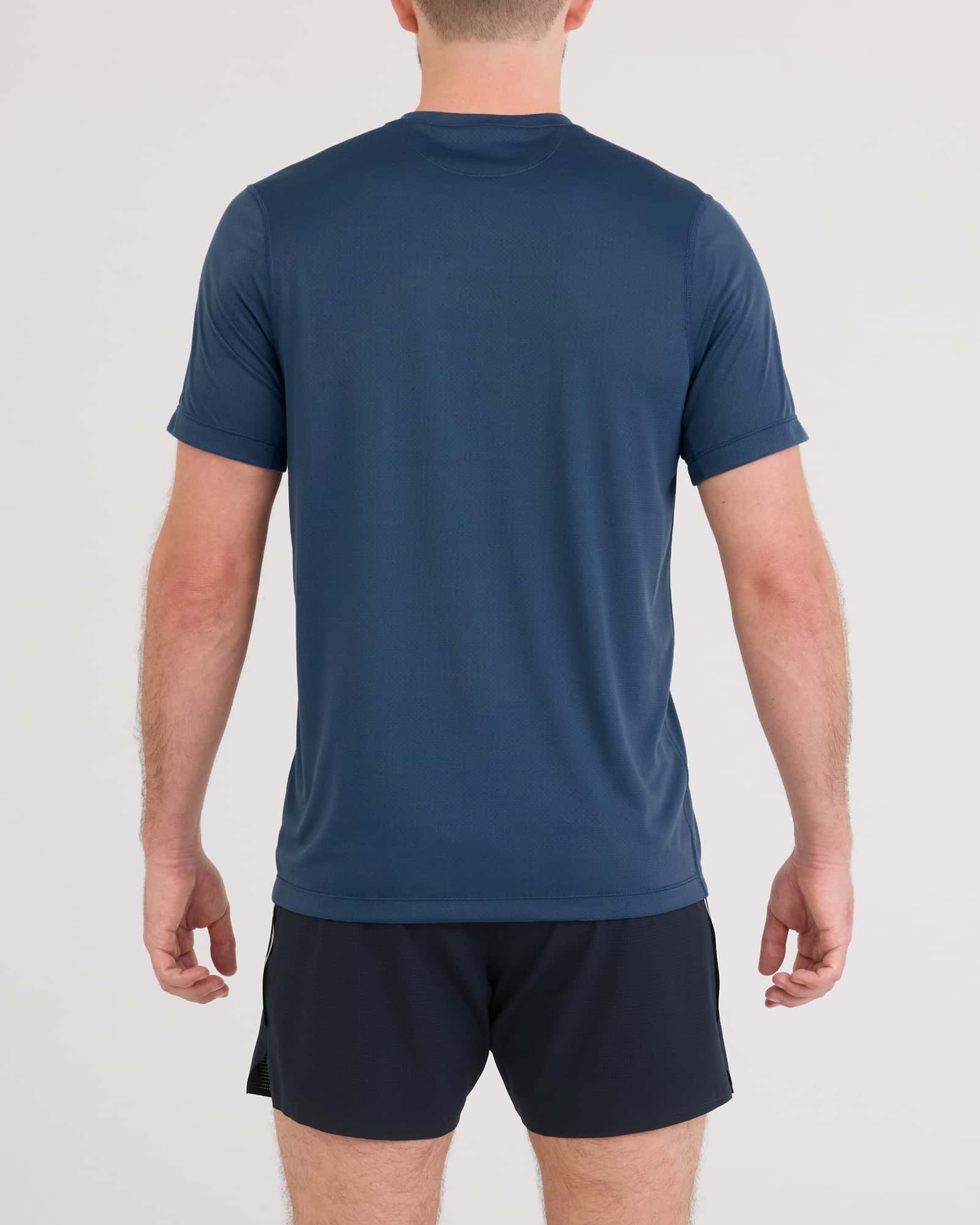 Back - Model wearing Multi-Sport Tech Tee in Washed Indigo