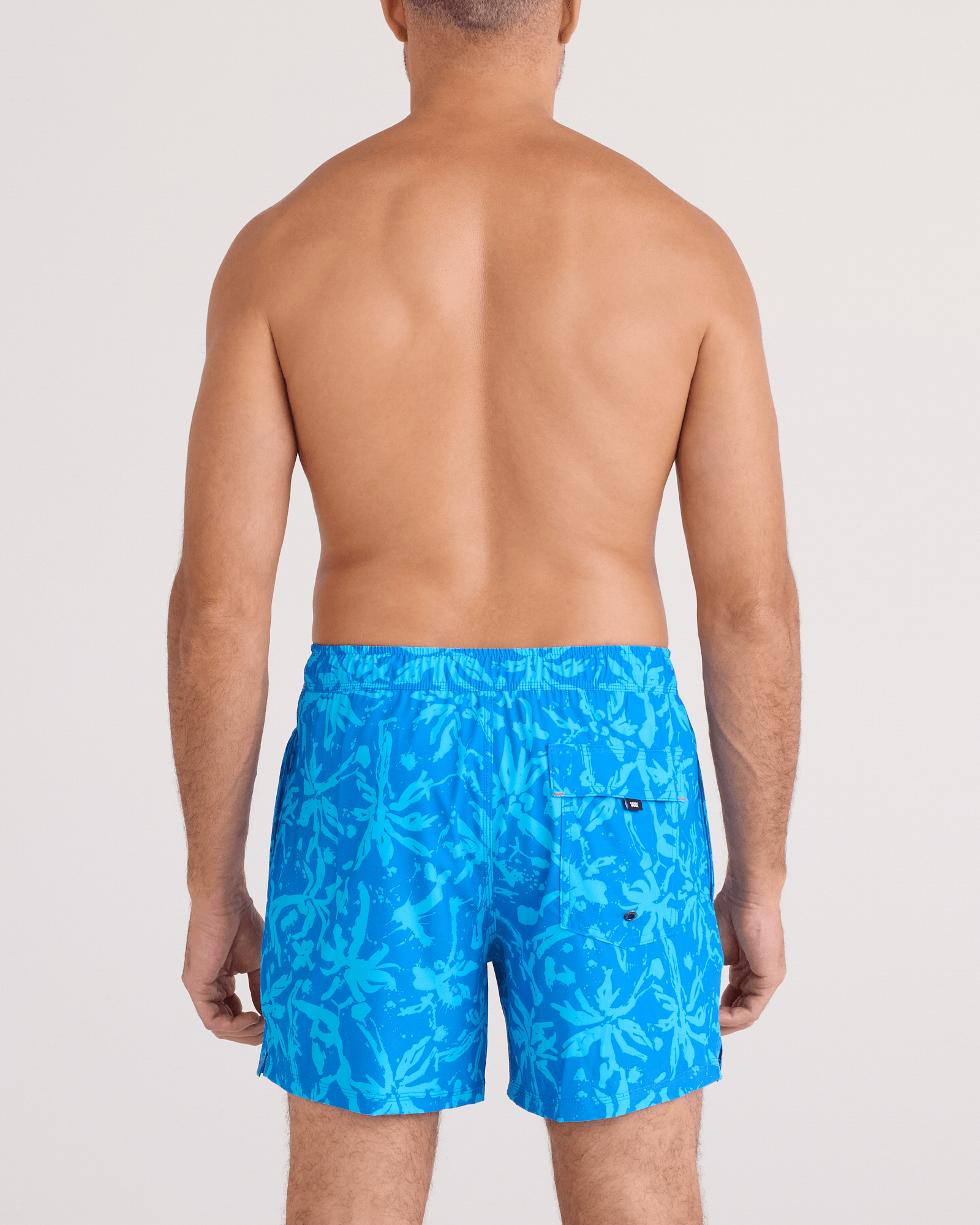 Back - Model wearing Oh Buoy 2N1 Swim Trunk 5" in Splash Palms-Bold Blue