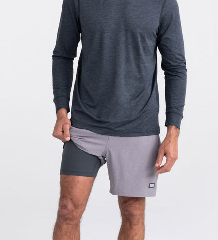 Man in grey shorts and shirt lifting leg to show liner