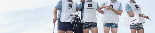 Four SAXX golf caddies standing arm and arm in their underwear