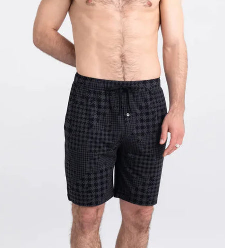 Man wearing black sleep shorts in a houndstooth print