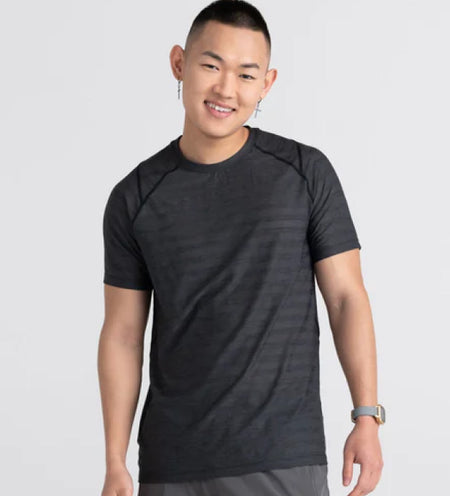 Man wearing a black mesh tee and a smart watch