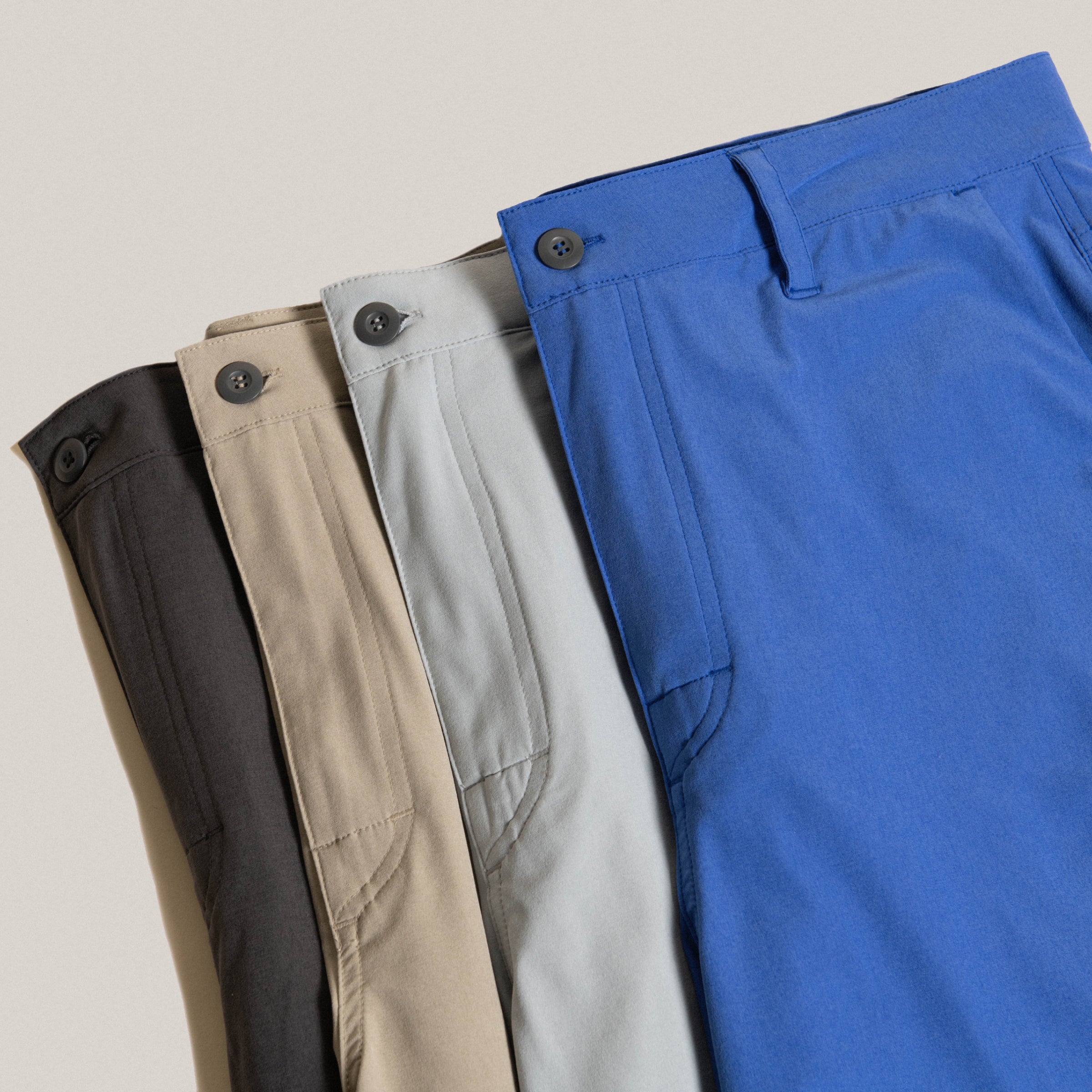A variety of solid color SAXX joggers laid out over a neutral background.