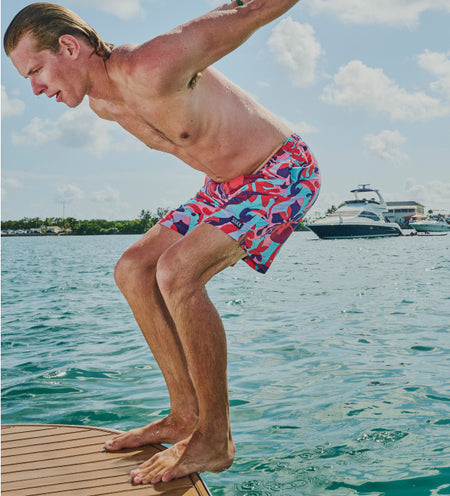 Man about to do a backflip off a boat while wearing colorful 2N1 Swim Shorts 