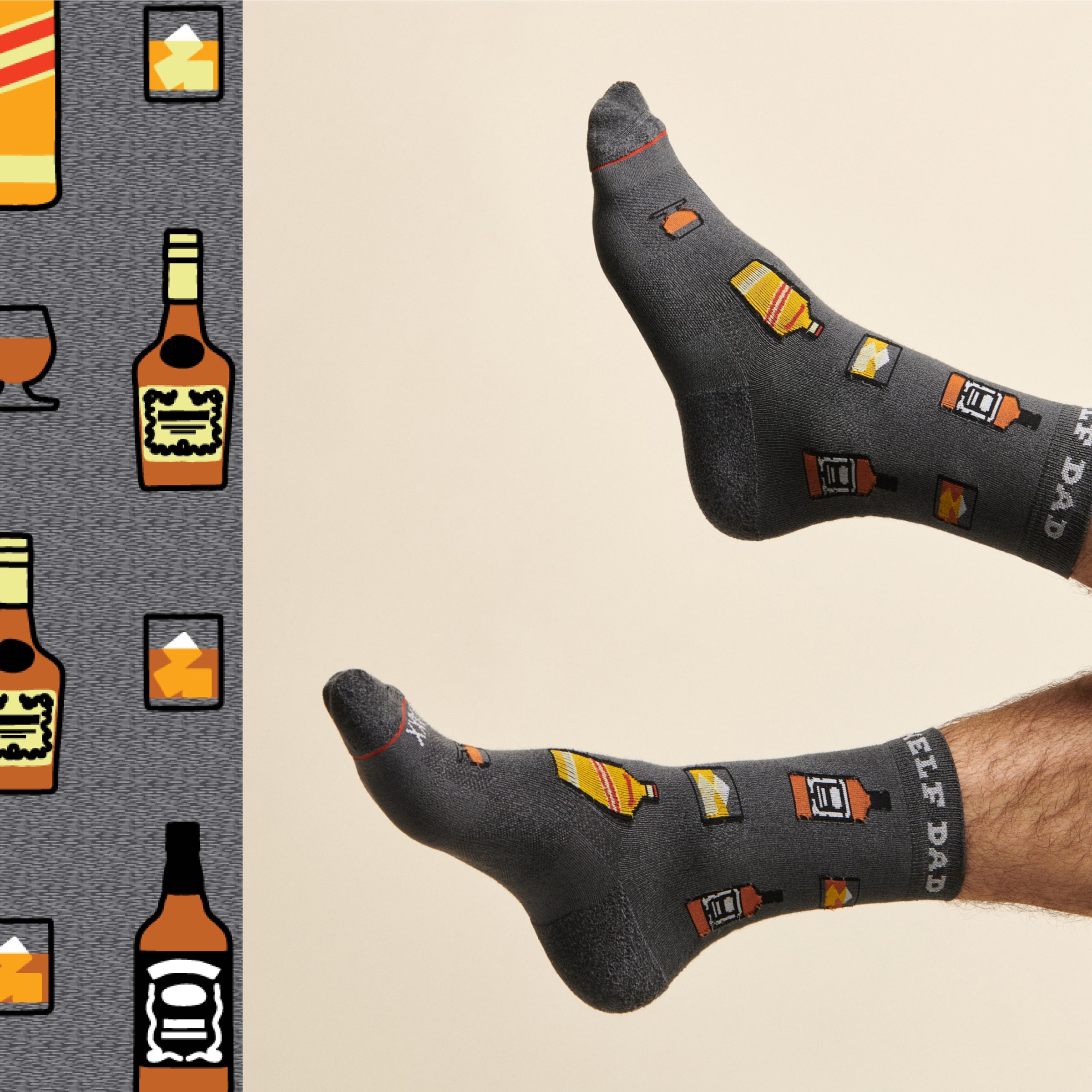 A pair of male feet wearing a pair of gray SAXX socks patterned in a cocktail theme, with "Top Shelf Dad" around the cuff.