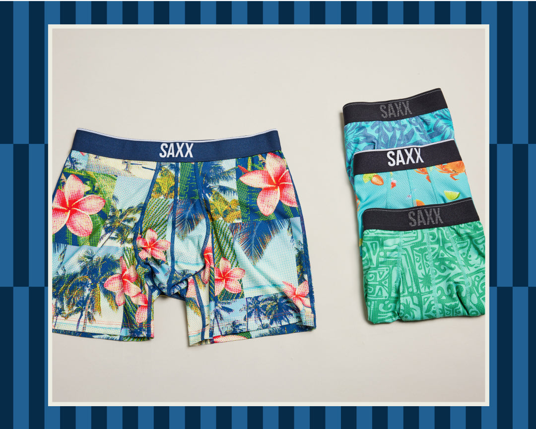 An image of brightly patterned boxer briefs set against a tonal dark blue and lighter blue vertical striped background.