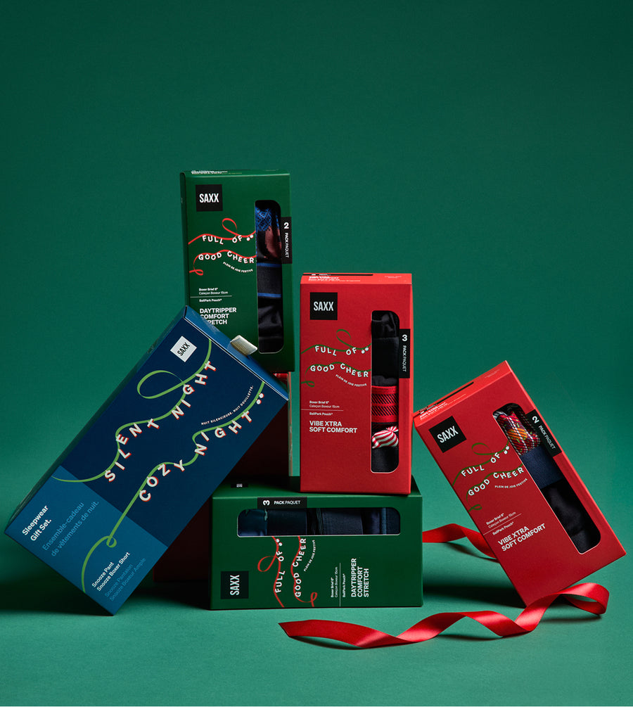 Collection of SAXX underwear boxes on a green background