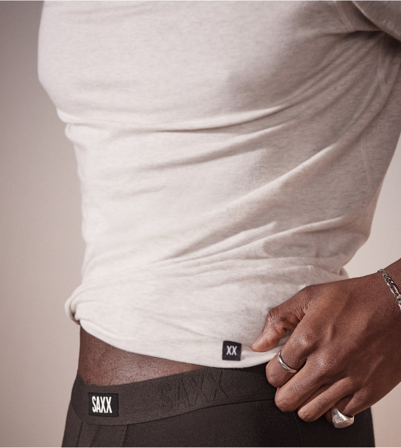 Close-up of a person wearing SAXX underwear with a neutral background