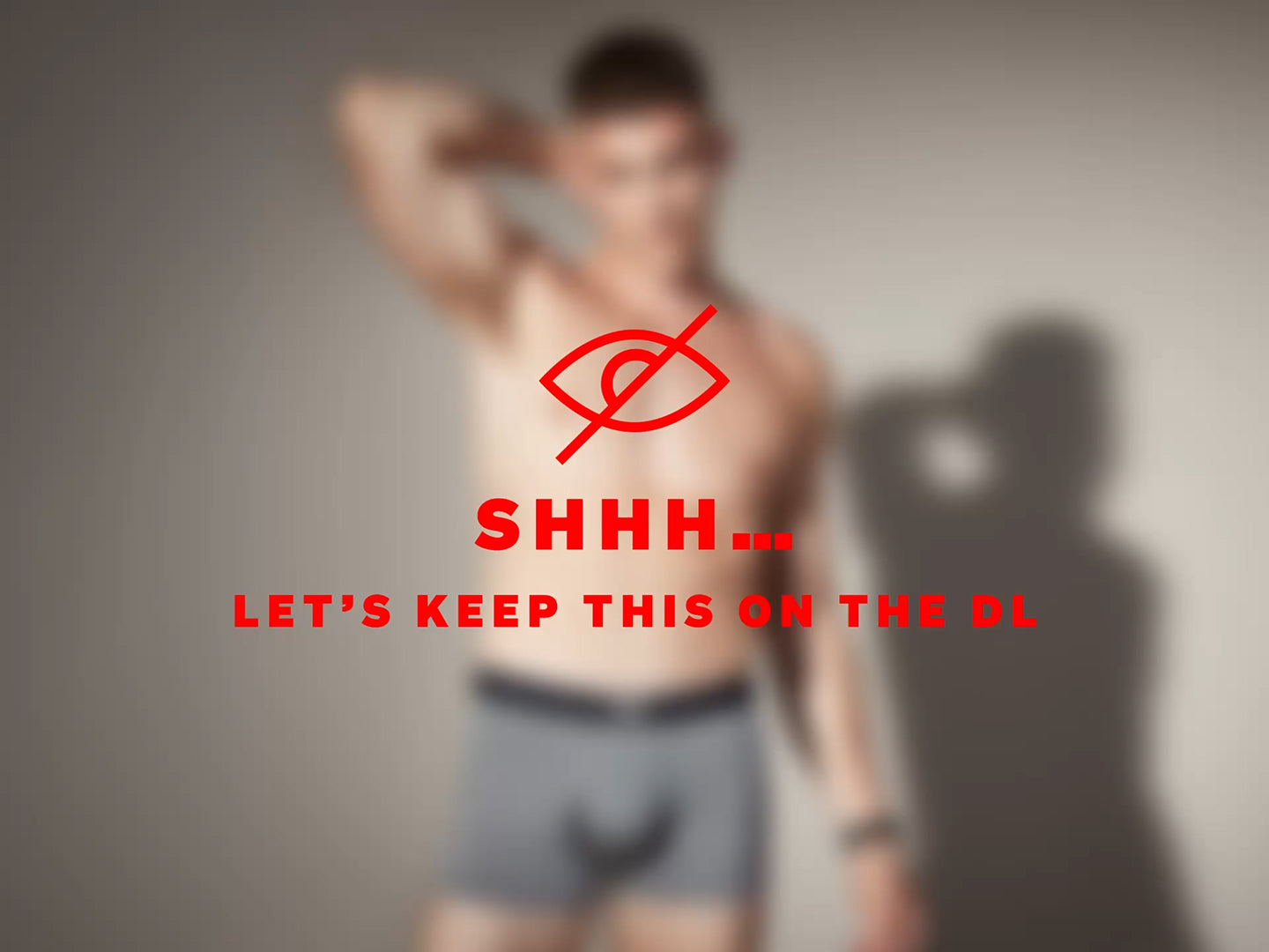 Man wearing underwear with a red logo and text on a gray background