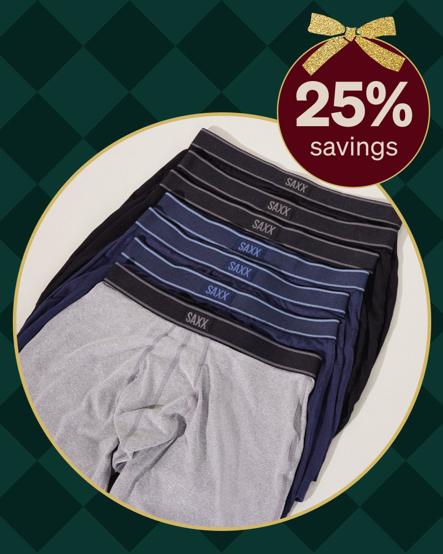 Stack of Saxx underwear with a 25% savings label on a green checkered background