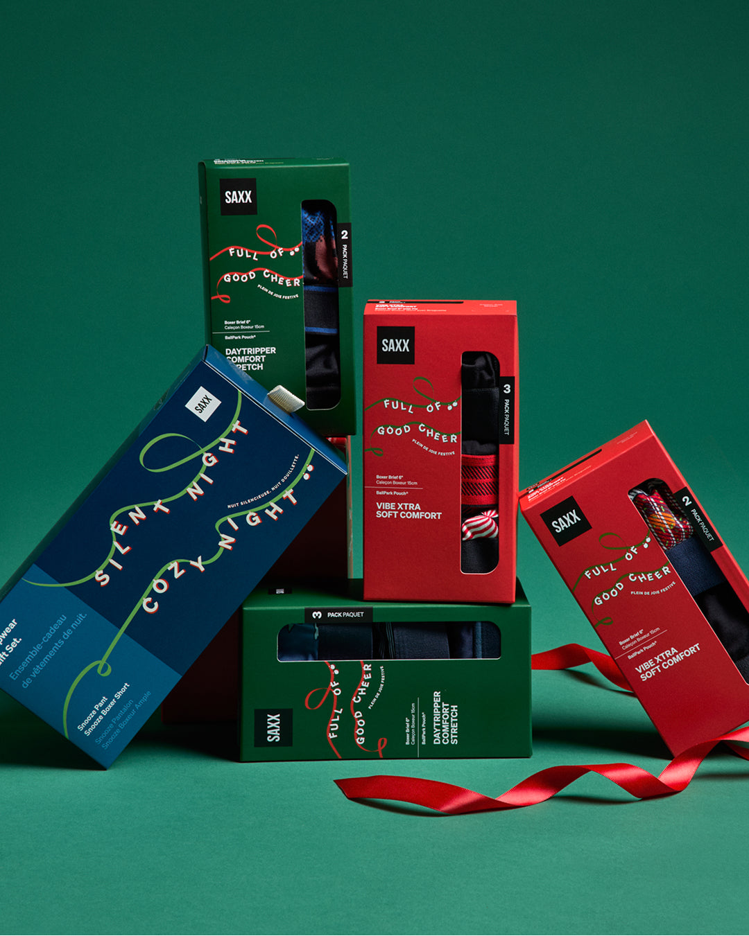 SAXX holiday gift boxes stacked against a green background.