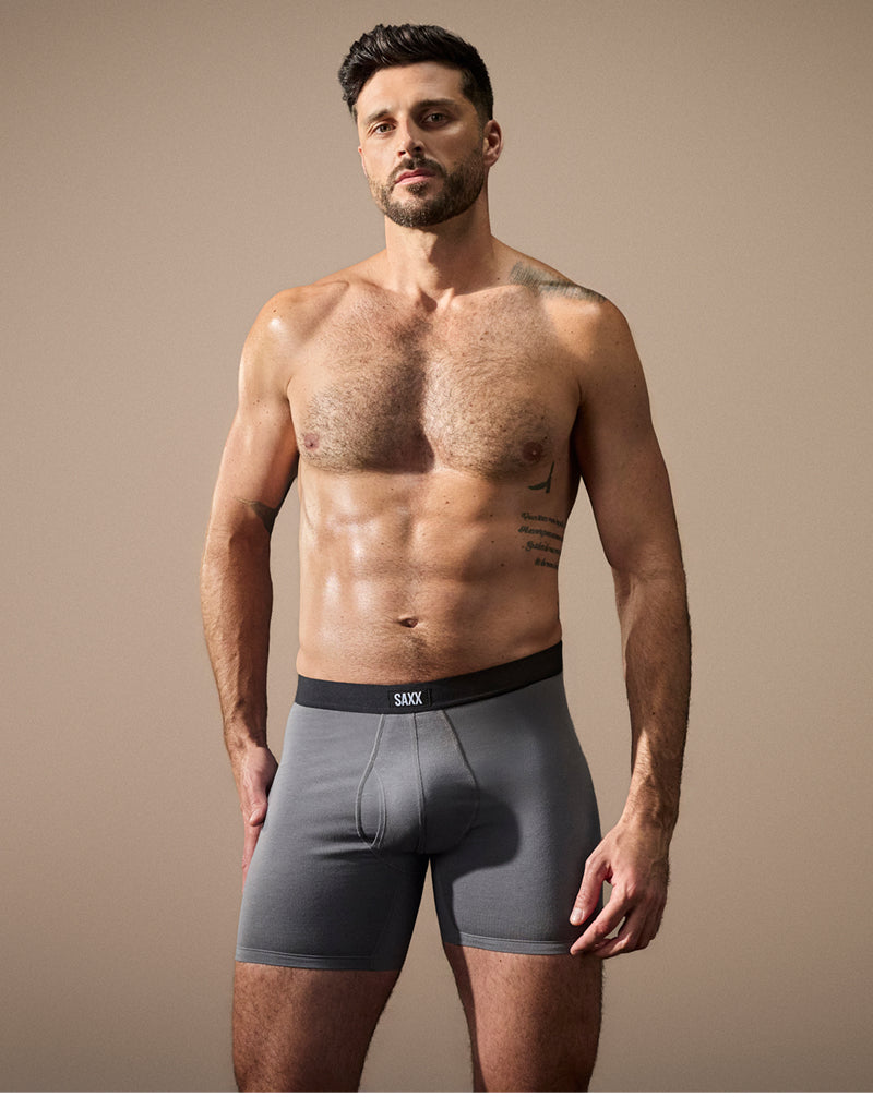Man wearing gray boxer briefs with a beige background