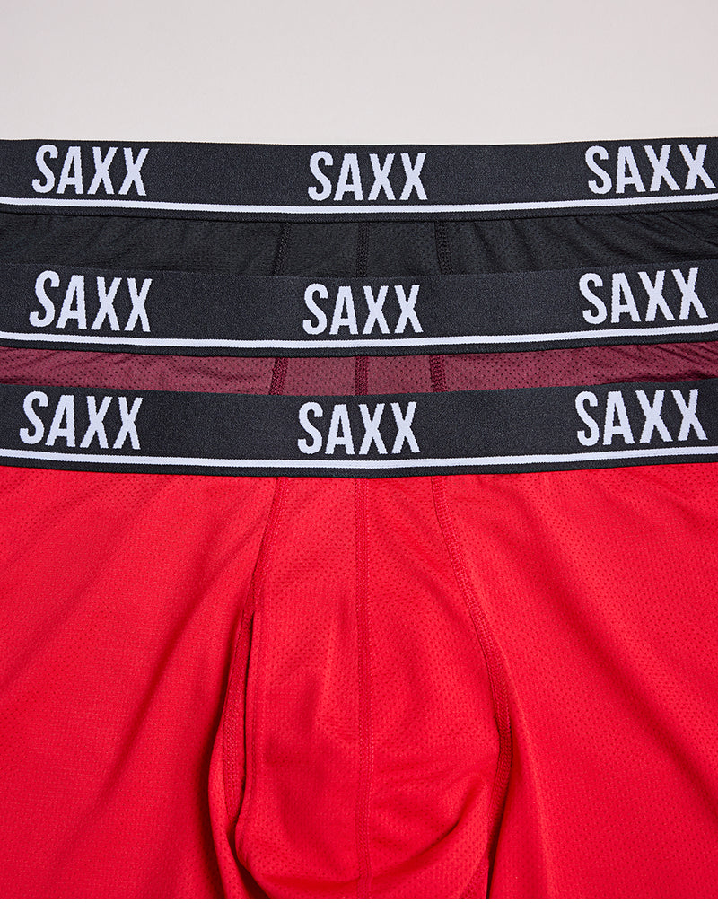 Red boxer briefs with multiple SAXX waistbands on a light gray background