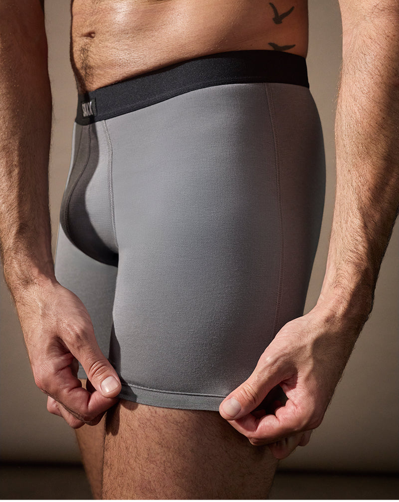 Gray boxer briefs worn by a person with a neutral background