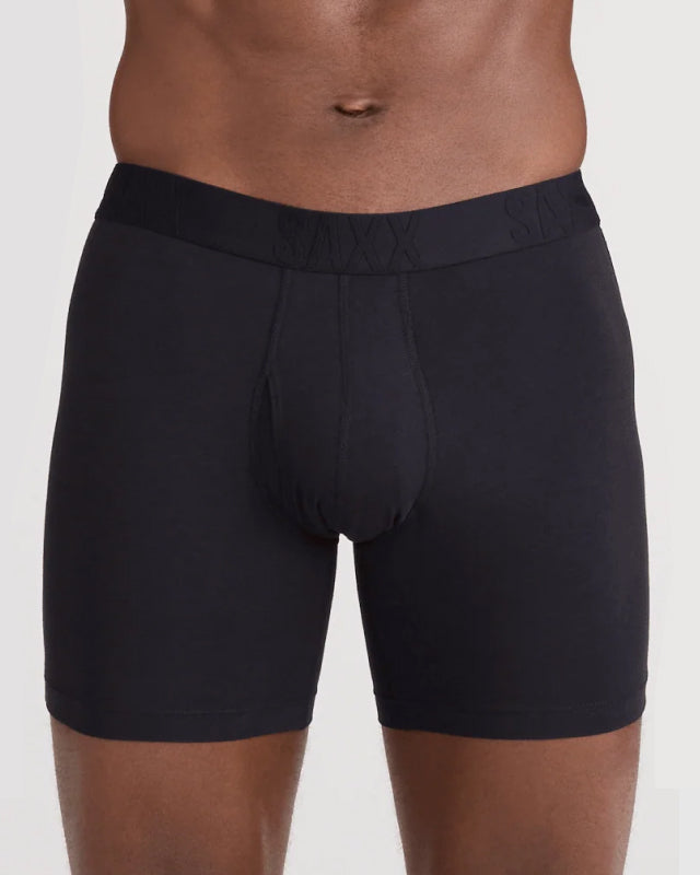 Model wearing black boxer briefs with 'SAXX' branding on a plain background