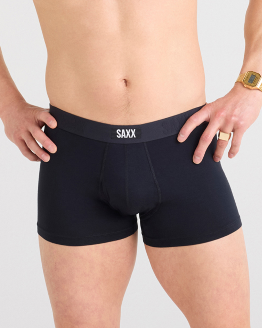 Model wearing black SAXX trunks on a white background
