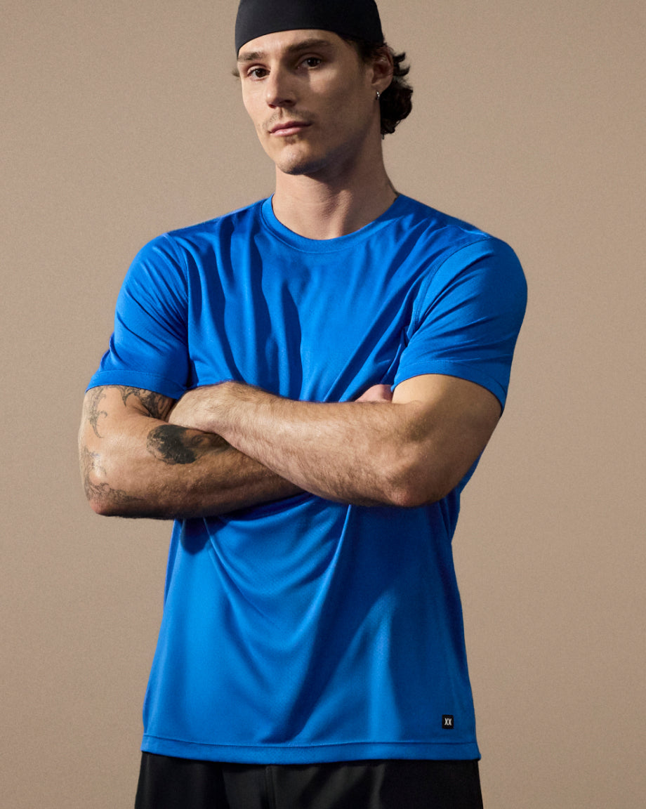 Man wearing a blue t-shirt with a beige background