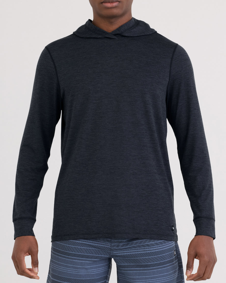 Person wearing a dark blue hoodie on a light gray background