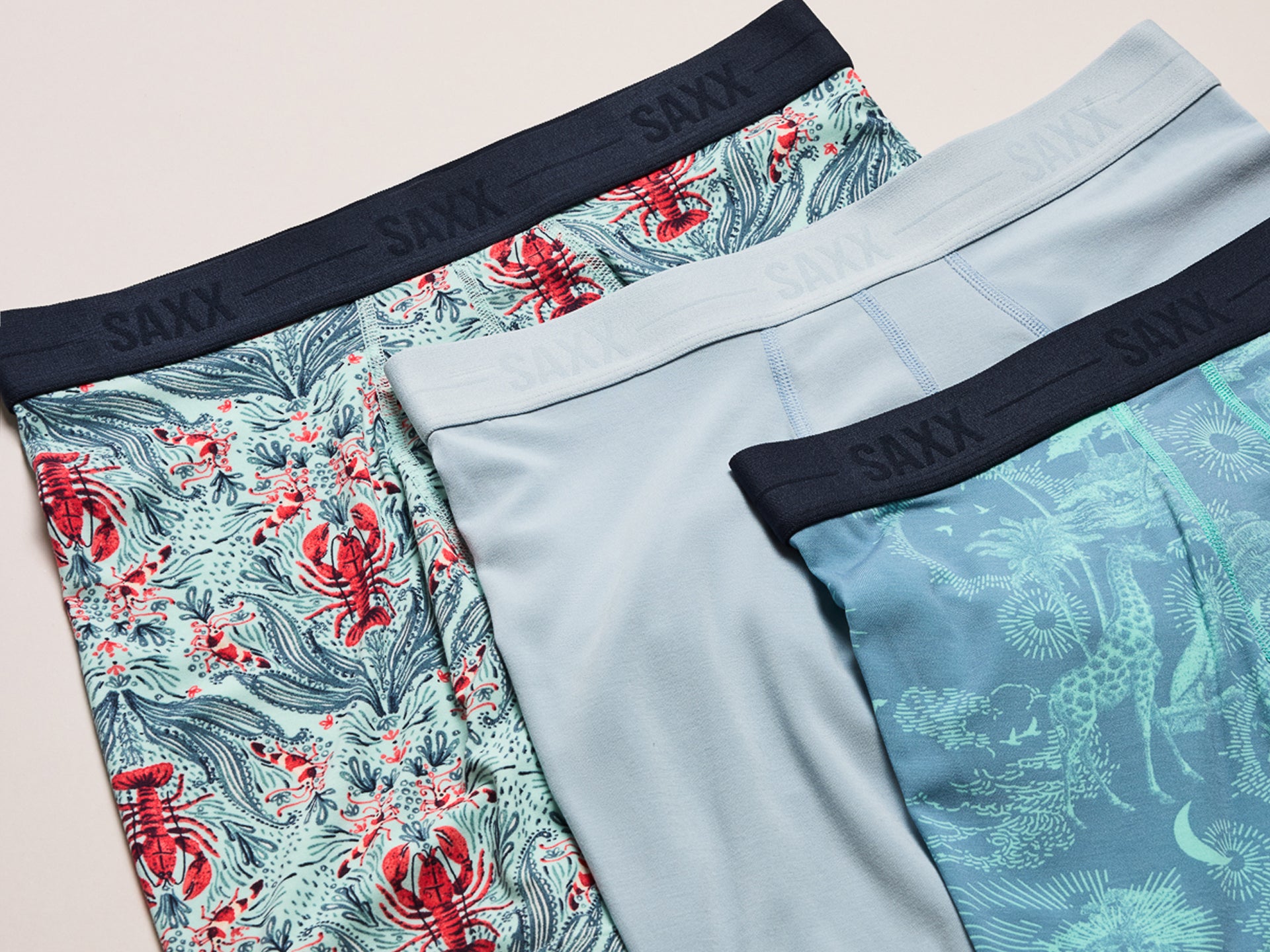 Three pairs of boxer briefs with different patterns and colors on a light background.
