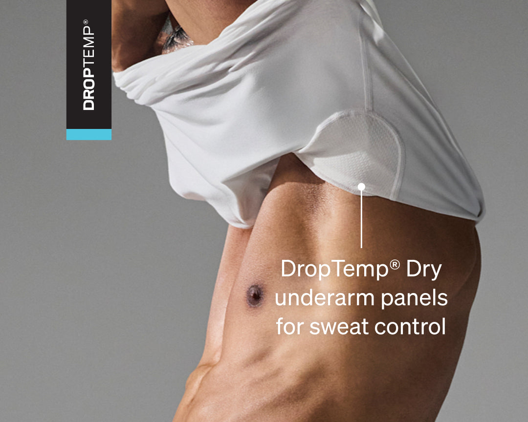 Man wearing a white SAXX undershirt with text highlighting 'DropTemp Dry underarm panels for sweat control'.