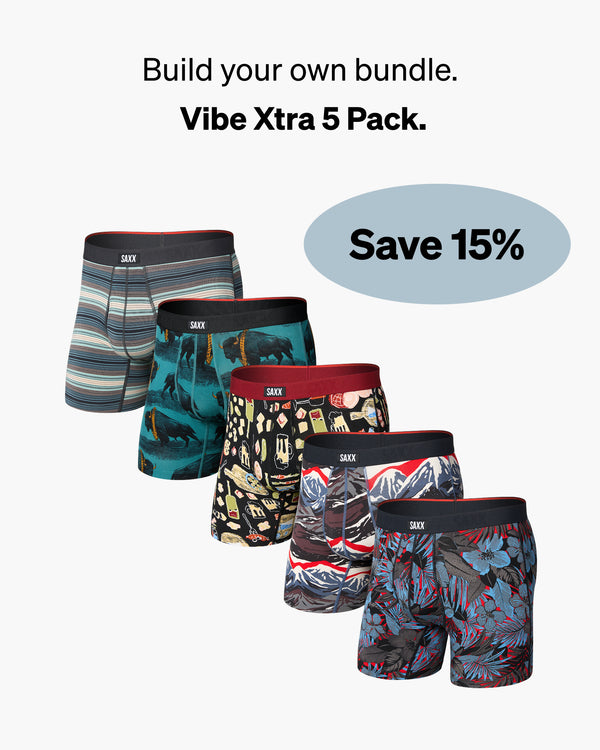 Set of five colorful SAXX boxer briefs with various patterns on a white background, with promo messaging saying "Build your own bundle. Vibe Xtra pack. Save 15%"