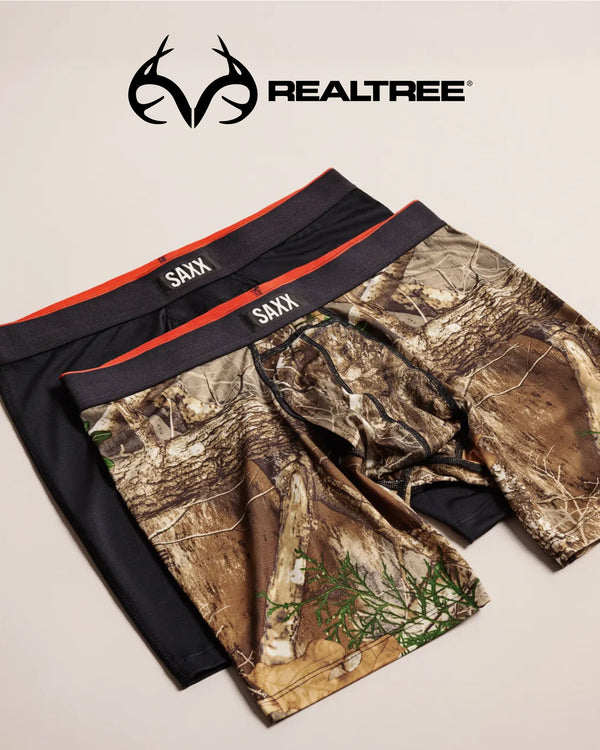 Camouflage and black SAXX underwear on a beige background, featuring the Realtree logo.
