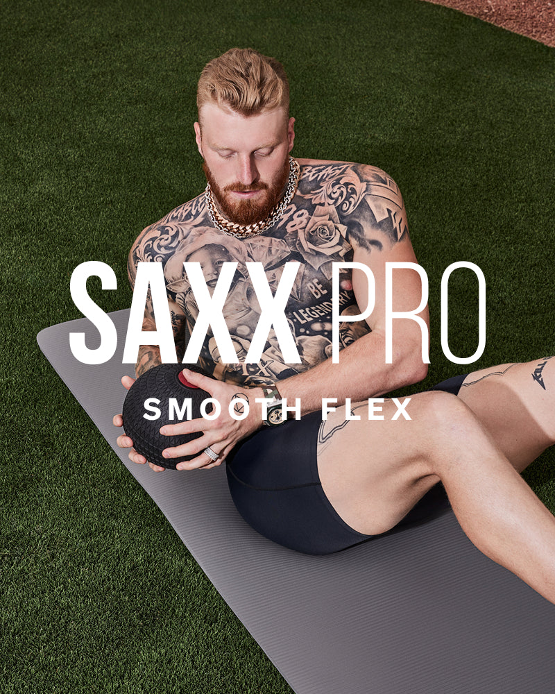 Maxx Crosby exercising with a SAXX PRO product on a grassy background