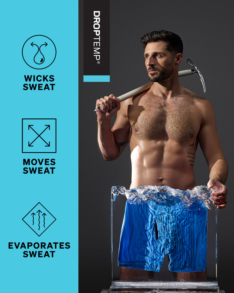 A shirtless man holding a pickaxe over his shoulder stands in a clear block of ice wearing bright blue DropTemp sweat shorts. The left side has a bright cyan panel with icons and text reading 'WICKS SWEAT,' 'MOVES SWEAT,' and 'EVAPORATES SWEAT,' plus the DropTemp brand name on a dark vertical panel.