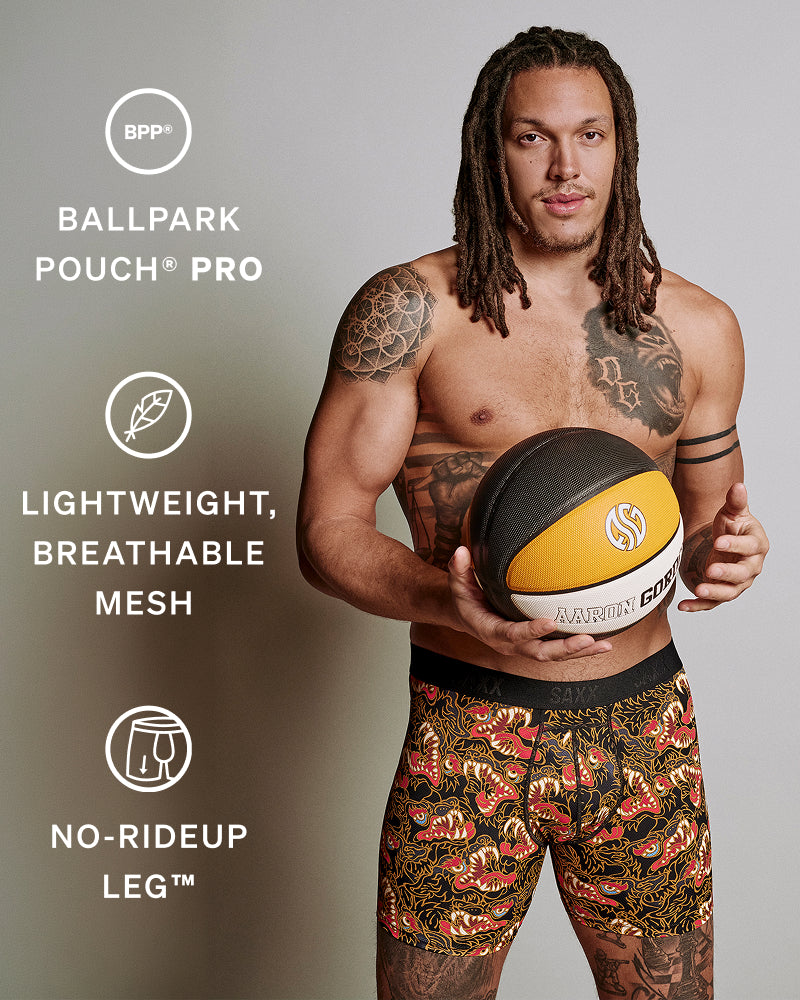 A shirtless man with tattoos holds a basketball while wearing patterned basketball shorts with text callouts on the left for BPP Ballpark Pouch Pro features.