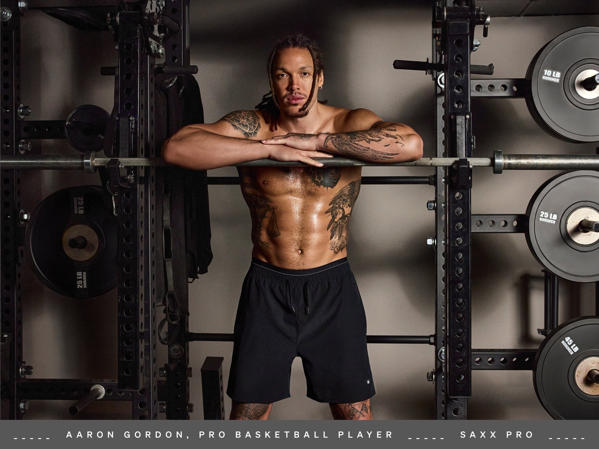 Pro Basketball Player and SAXX Gamechanger Aaron Gordon poses in a weight lifting gym