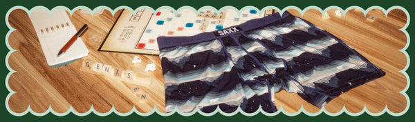 Blue Boxer Briefs in a wintery print draped over a Scrabble board