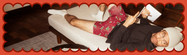 Man wearing black long sleeve tee and red Boxer Briefs while writing in journal