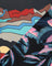A close-up of a fabric with the top-left section shows a stylized landscape with red mountains, blue zigzag lines, beige hills, and a yellow sun on a dark background. Bottom right shows black and pink tropical print. 