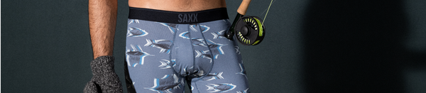 Man in grey patterned underwear and gloves holding fishing rod
