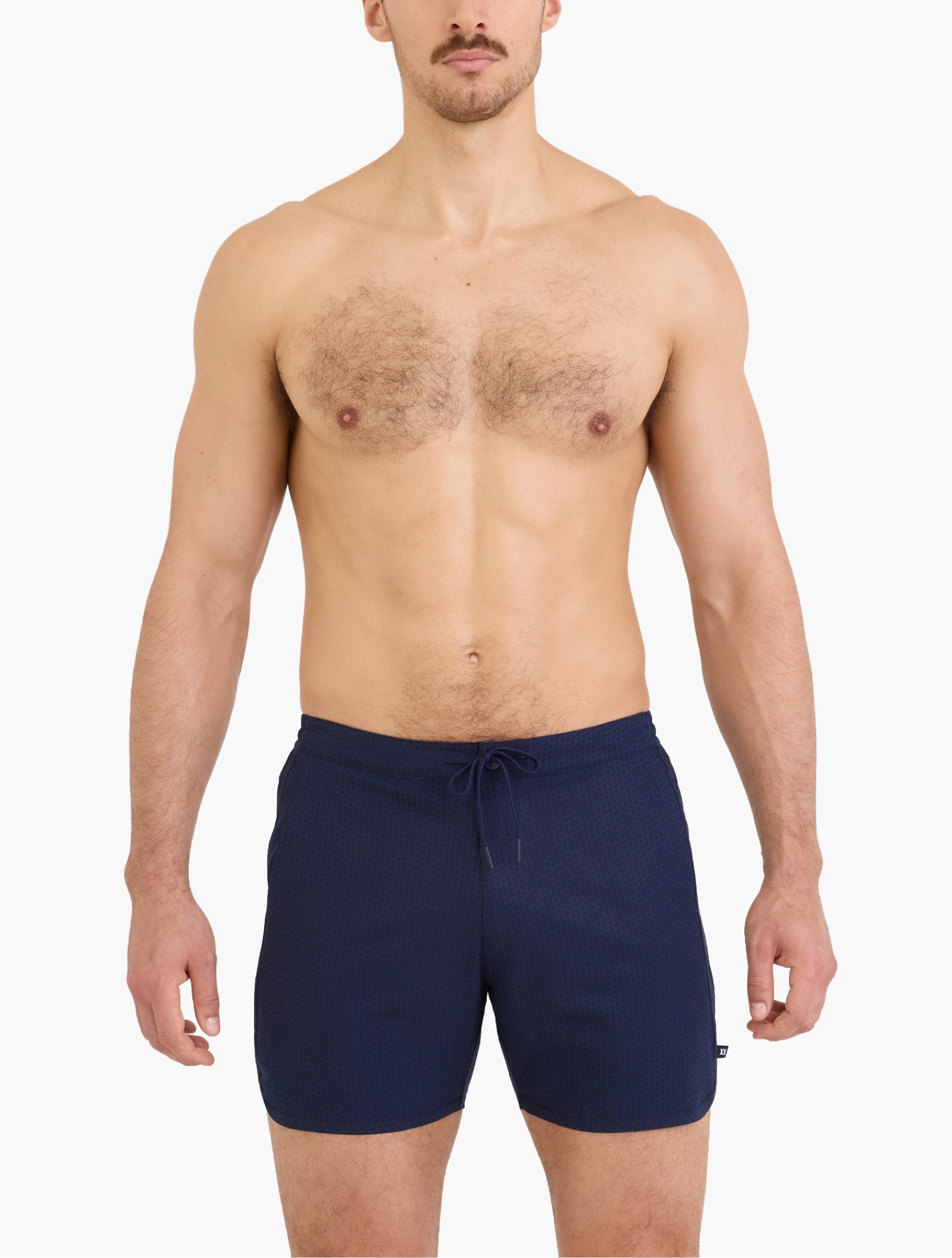 Model wearing navy swim trunk with drawstring waist standing against white background showcasing relaxed swim fit