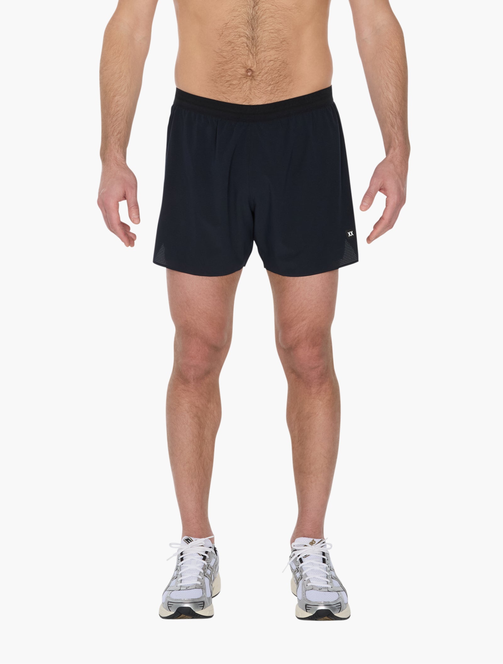 Model wearing black lightweight running short with elastic waistband standing against white background