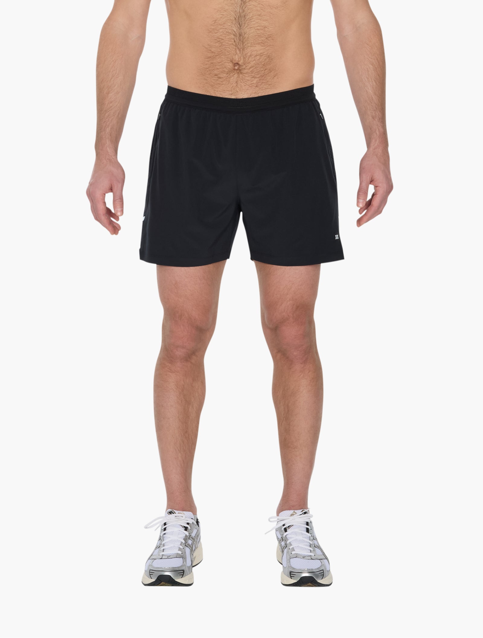 Model wearing black running short with elastic waistband and drawstring standing against white background