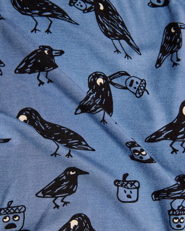 Blue fabric with black bird illustrations and acorns on a blue background