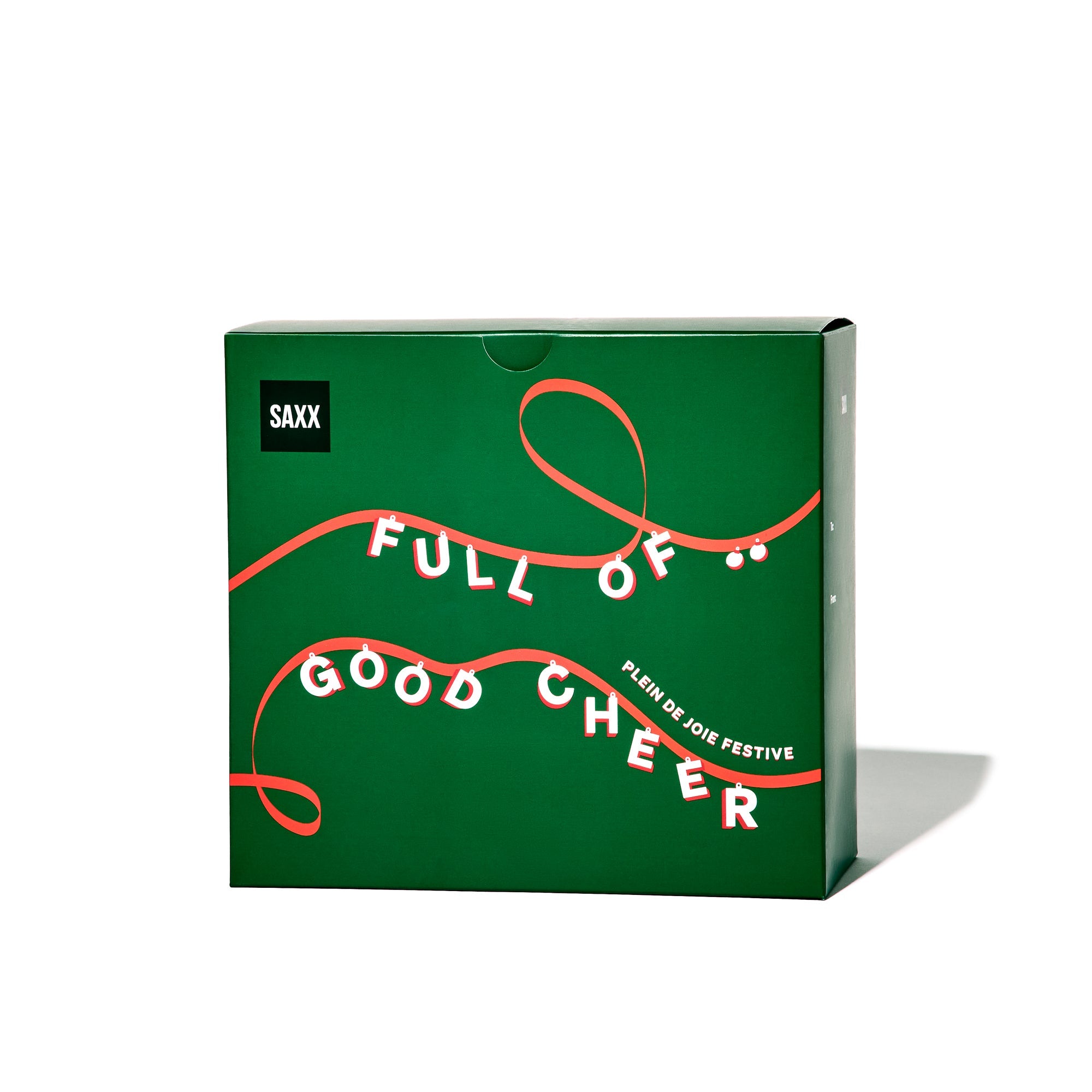 Green box with red text and ribbon design, featuring the brand 'SAXX'.
