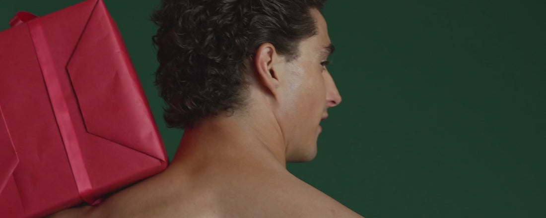 A person wearing a santa hat and SAXX Underwear in holiday prints