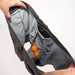 Man's hands revealing inside of 2N1 shorts showing liner with pouch holding two ping pong balls