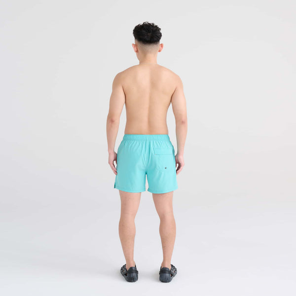 Back - Model wearing Oh Buoy 2N1 Swim Trunk 5" in Turquoise
