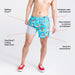 Man in blue cartoon print swim shorts and shoes lifting short leg to reveal liner
